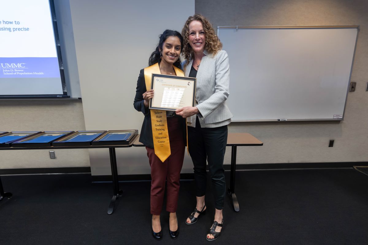 Student standing with Dr. Reneker with stole and certificate at the 2023 SOPH Research Day